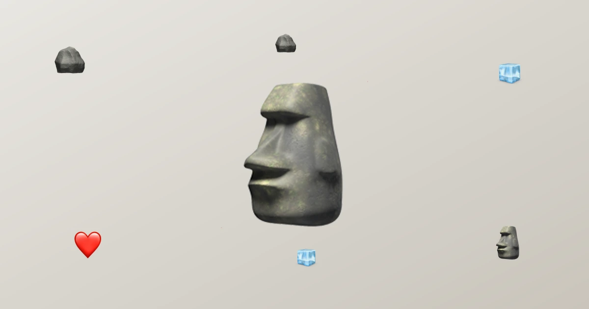 Emoji batu Moai 🗿 berukuran besar dengan aksen emoji batu, es batu, dan hati di sekitarnya